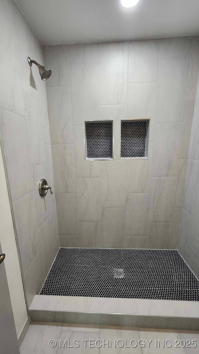 full bath featuring a tile shower and visible vents