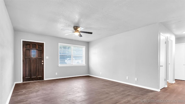 entrance foyer featuring a ceiling fan, a textured ceiling, baseboards, and wood finished floors