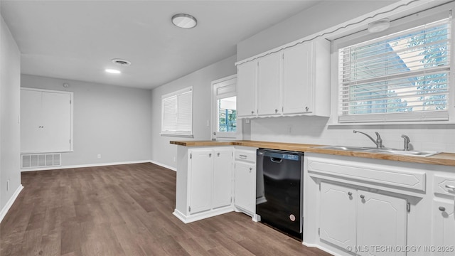 kitchen featuring black dishwasher, visible vents, butcher block counters, white cabinetry, and a sink