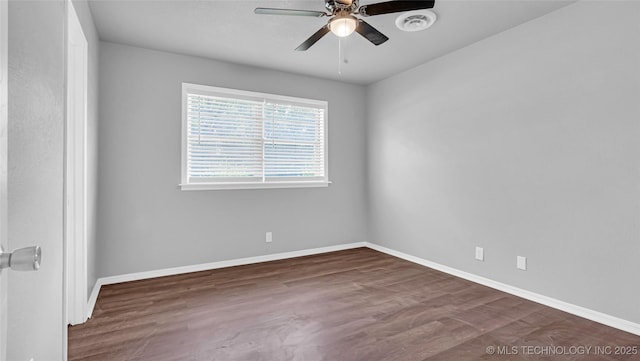 spare room featuring visible vents, wood finished floors, a ceiling fan, and baseboards