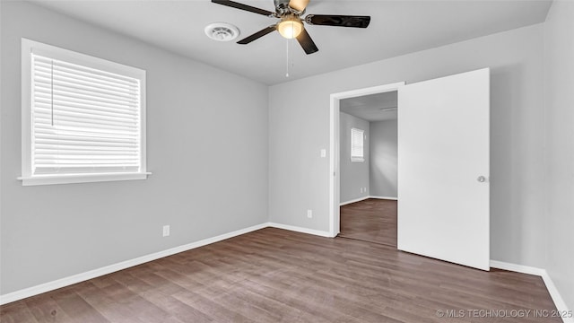 empty room with ceiling fan, baseboards, and wood finished floors