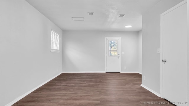 foyer featuring baseboards, visible vents, and wood finished floors