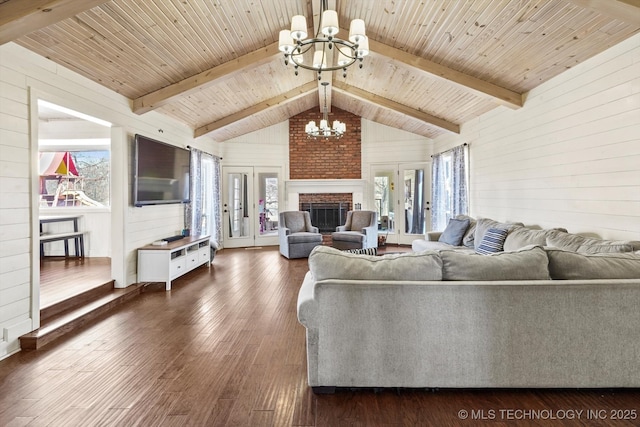 living room featuring a chandelier, dark wood-type flooring, wood ceiling, french doors, and beamed ceiling