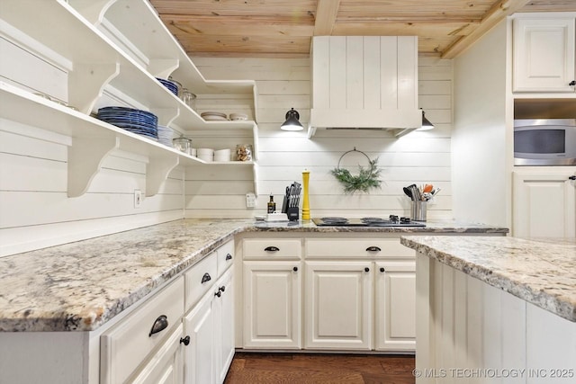 kitchen with open shelves, stainless steel microwave, white cabinetry, light stone countertops, and wooden ceiling