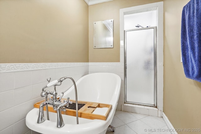 full bathroom featuring a freestanding bath, tile patterned flooring, a shower stall, and tile walls