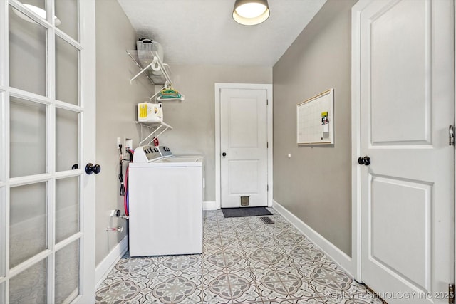 laundry area featuring laundry area, washing machine and clothes dryer, and baseboards