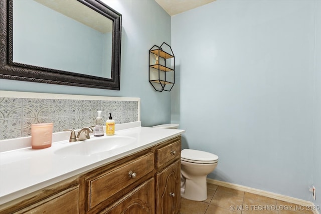 bathroom featuring toilet, vanity, baseboards, and tile patterned floors