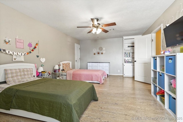 bedroom featuring wood finished floors, visible vents, and a ceiling fan