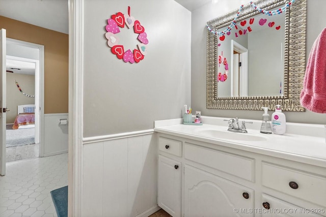 bathroom with a wainscoted wall, tile patterned floors, and vanity