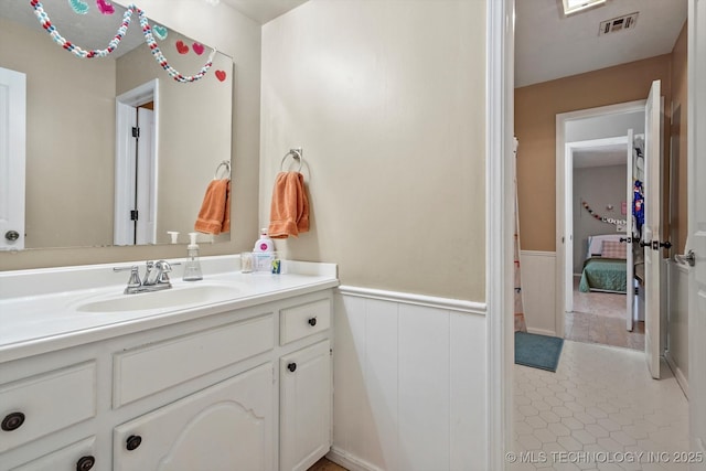 bathroom featuring wainscoting, vanity, visible vents, and tile patterned floors