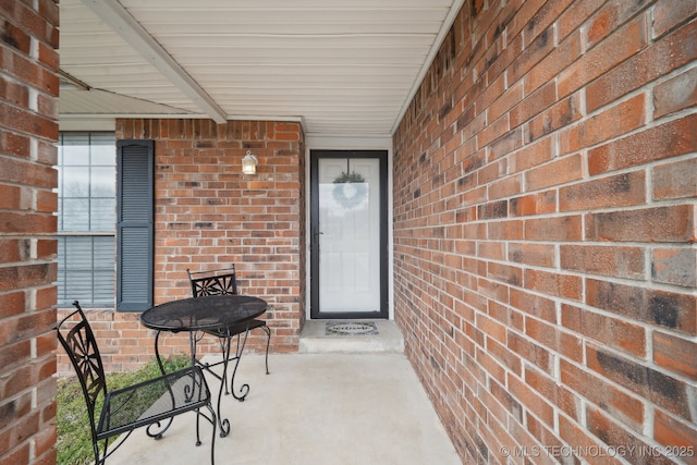 view of exterior entry featuring brick siding