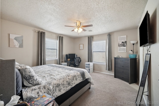 bedroom featuring light colored carpet, ceiling fan, a textured ceiling, and baseboards