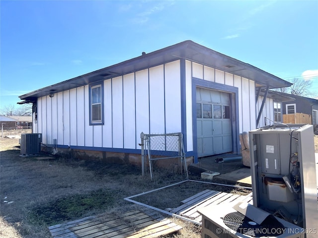 view of property exterior with entry steps, central AC, and board and batten siding