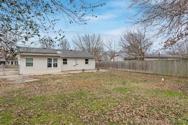 back of property with a fenced backyard and a lawn