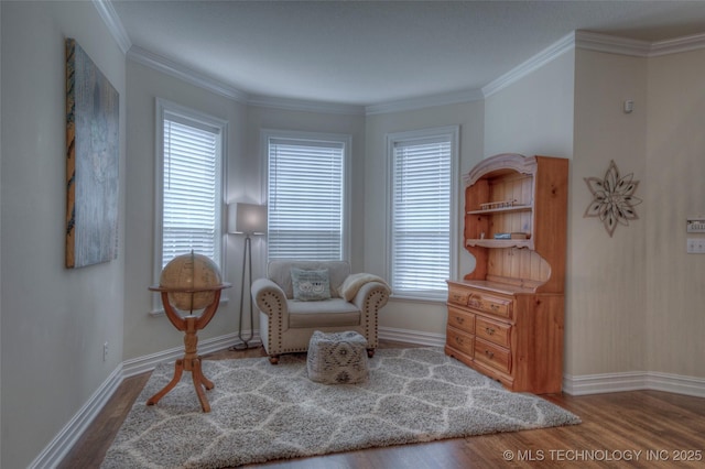 sitting room with crown molding, baseboards, and wood finished floors