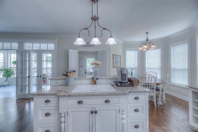 kitchen featuring a healthy amount of sunlight, dark wood-style flooring, and crown molding