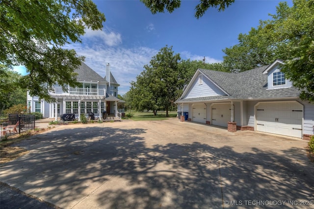 view of side of property featuring a garage and a shingled roof