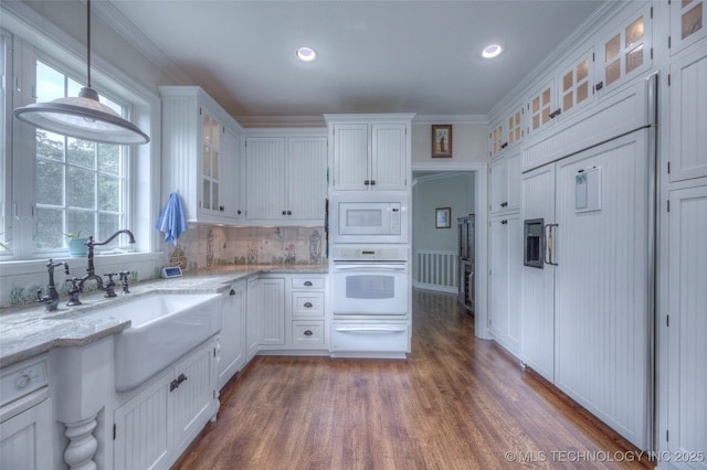 kitchen featuring white appliances, a sink, white cabinetry, a healthy amount of sunlight, and a warming drawer