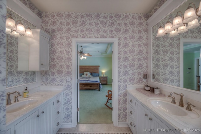 full bath with two vanities, a sink, ensuite bathroom, and wallpapered walls