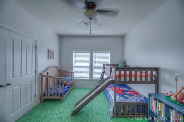 carpeted bedroom featuring baseboards, visible vents, and a ceiling fan