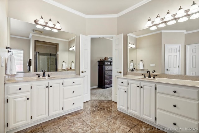 bathroom featuring crown molding, a stall shower, two vanities, and a sink