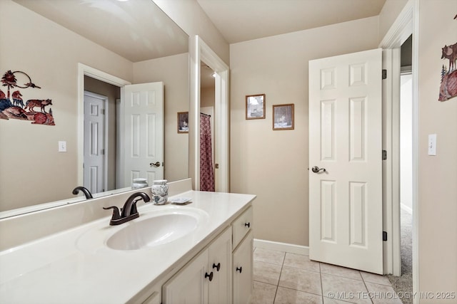 bathroom with tile patterned flooring, baseboards, and vanity