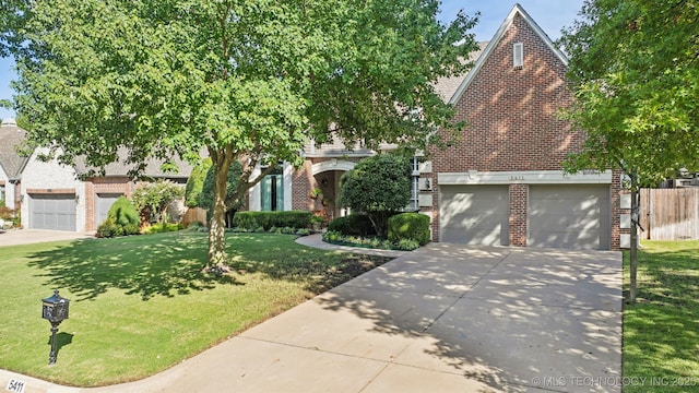 view of property hidden behind natural elements featuring brick siding, concrete driveway, an attached garage, fence, and a front lawn