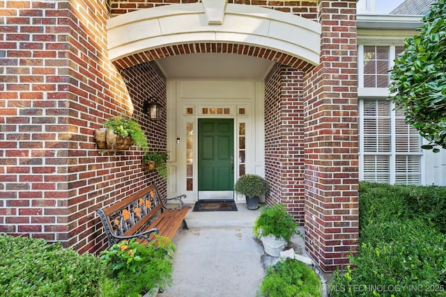 entrance to property featuring brick siding