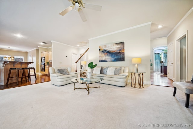 living area featuring carpet floors, ceiling fan, baseboards, and ornamental molding