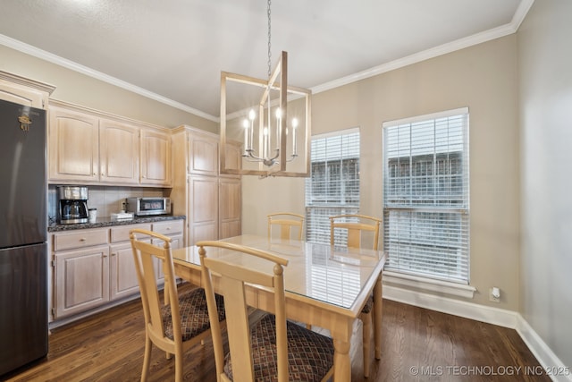 dining area featuring ornamental molding, dark wood-style flooring, a notable chandelier, and baseboards