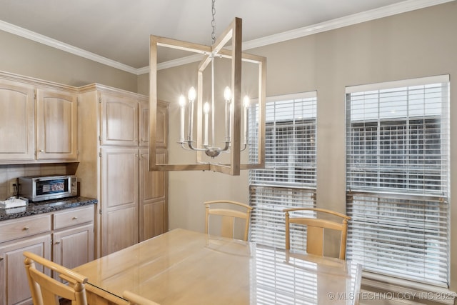 dining space with a toaster, ornamental molding, and a notable chandelier