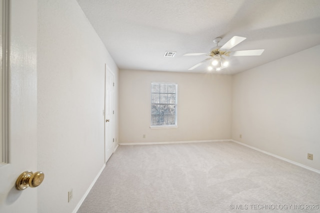 unfurnished room featuring a skylight, visible vents, light carpet, ceiling fan, and baseboards