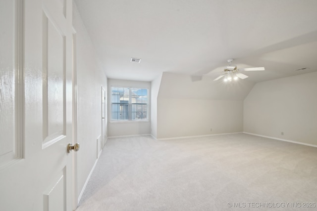 additional living space featuring lofted ceiling, baseboards, visible vents, and light colored carpet