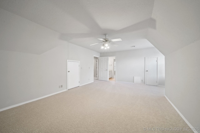 bonus room with lofted ceiling, visible vents, light carpet, ceiling fan, and baseboards