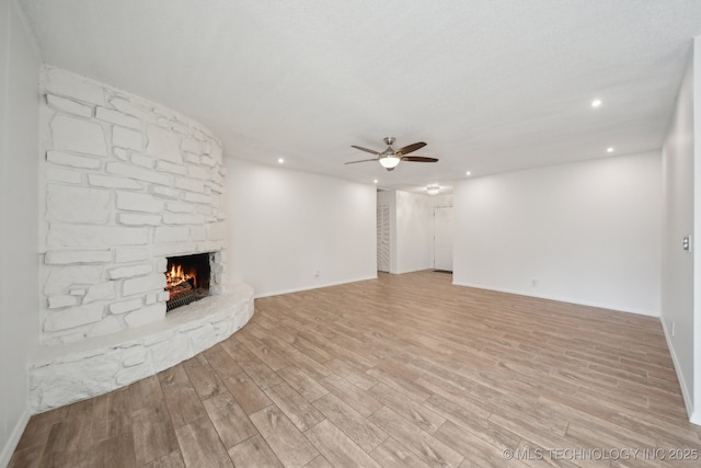 unfurnished living room with a fireplace, recessed lighting, light wood-style flooring, ceiling fan, and baseboards