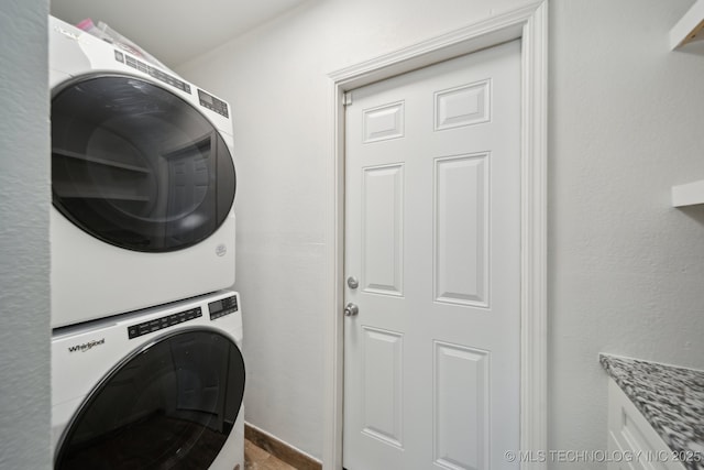 clothes washing area featuring laundry area and stacked washer and dryer