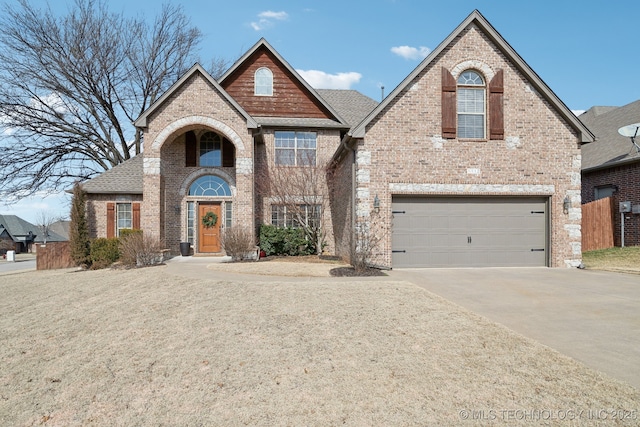 view of front of house featuring a garage, driveway, roof with shingles, and brick siding