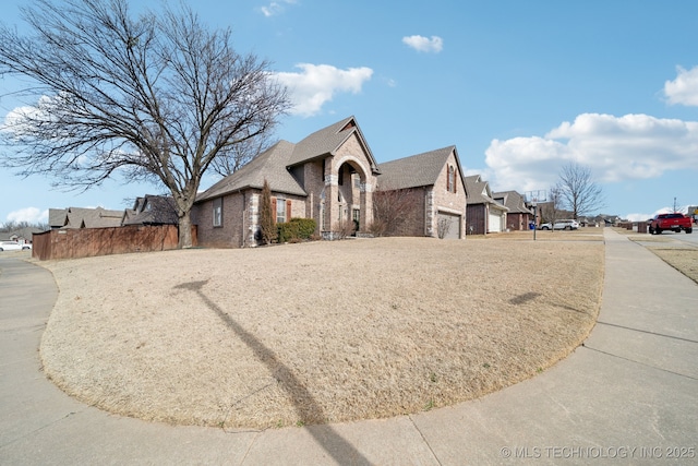 view of property exterior featuring a garage, driveway, and brick siding