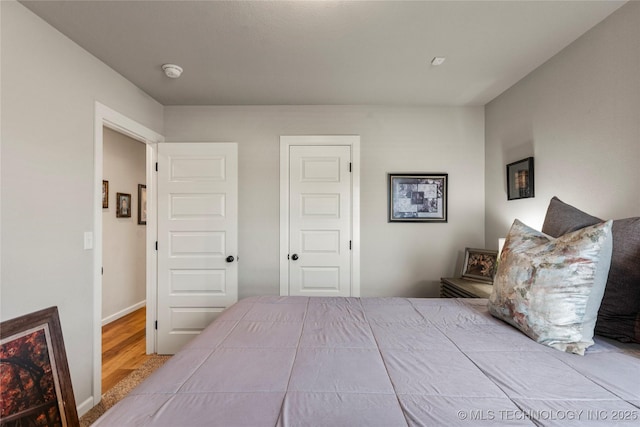 bedroom with baseboards and wood finished floors