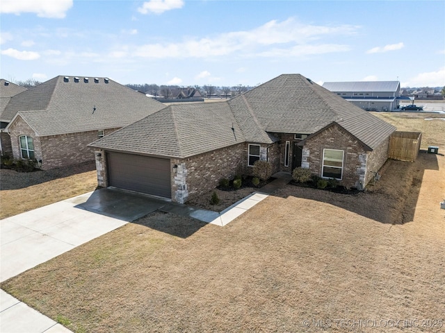 view of front of home featuring a garage, concrete driveway, brick siding, and a shingled roof