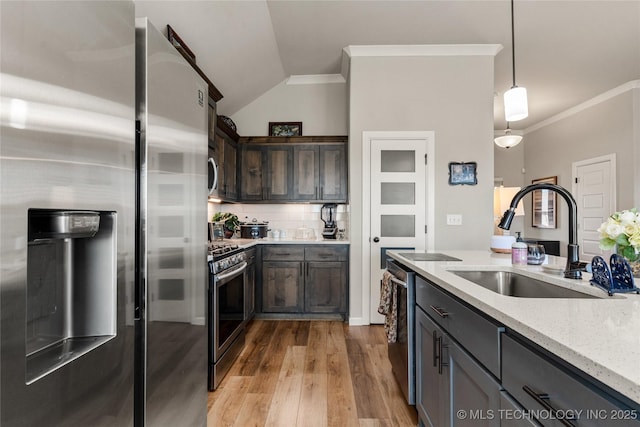 kitchen with ornamental molding, appliances with stainless steel finishes, a sink, and decorative backsplash