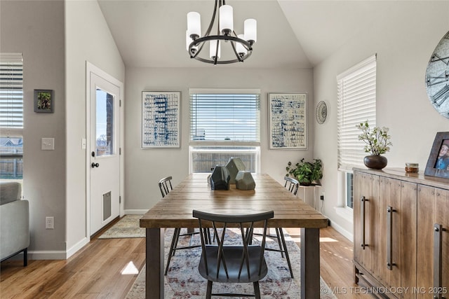 dining area with light wood finished floors, baseboards, vaulted ceiling, and a notable chandelier