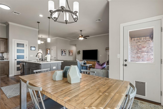 dining room with ceiling fan, dark wood-type flooring, visible vents, baseboards, and crown molding