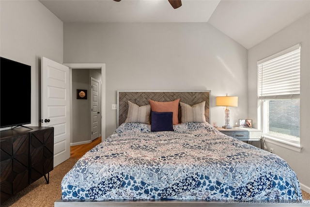 bedroom with lofted ceiling, ceiling fan, and light colored carpet