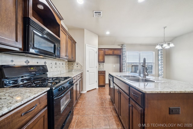 kitchen with black appliances, tasteful backsplash, visible vents, and a sink