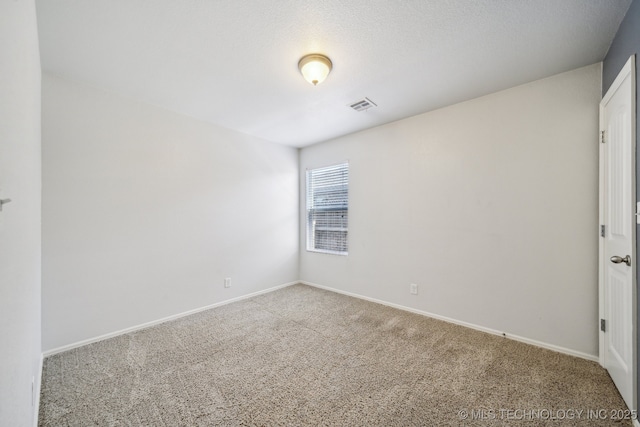 empty room featuring carpet, visible vents, and baseboards