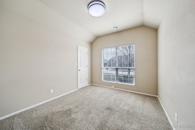 carpeted spare room featuring visible vents, vaulted ceiling, and baseboards