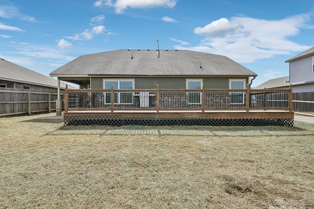 back of property featuring stucco siding, a fenced backyard, a wooden deck, and a yard