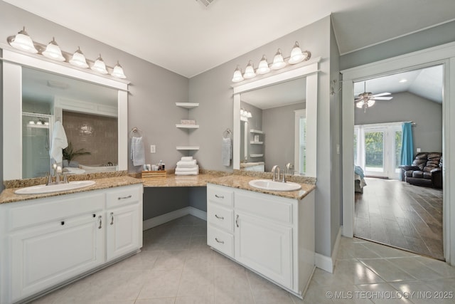 ensuite bathroom featuring tile patterned flooring, two vanities, and a sink