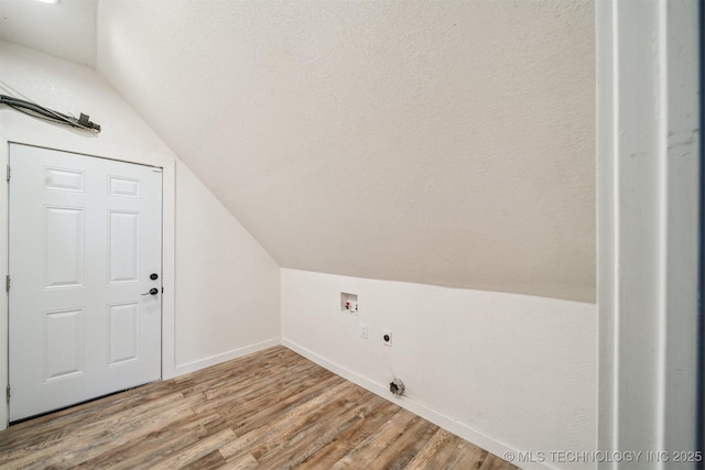 bonus room with lofted ceiling, a textured ceiling, baseboards, and light wood-style floors